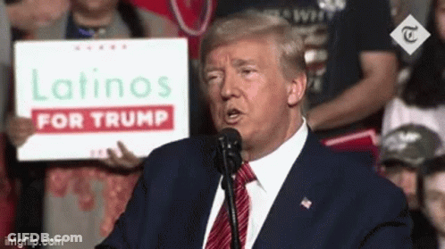 Donald Trump Is Giving A Speech At A Campaign Event While Holding A Sign That Says Latinos For Trump . GIF
