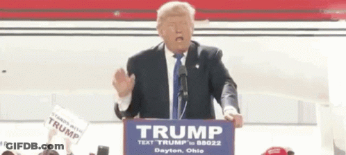 Donald Trump Is Giving A Speech At A Podium While Wearing A Fake Face . GIF