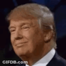Donald Trump Is Smiling And Wearing A Suit And Tie In A Close Up Of His Face . GIF