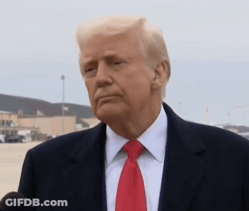 Donald Trump Is Wearing A Suit And Red Tie While Talking Into A Microphone . GIF