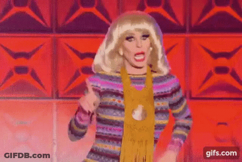 Drag Queen Dancing In Colorful Sweater And Scarf On Stage GIF