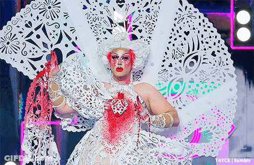 Drag Queen In White And Pink Costume With Heart GIF
