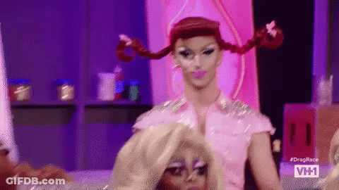 Drag Queen Putting Wig On Another Drag Queen On Stage GIF