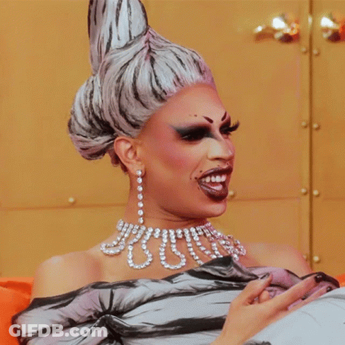 Drag Queen Wearing Pearls And Earrings GIF