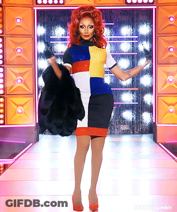Drag Queen With Red Hair Walking Down Runway Holding Fur Coat GIF