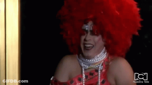 Drag Queen With Red Wig And Pearls Smiling GIF