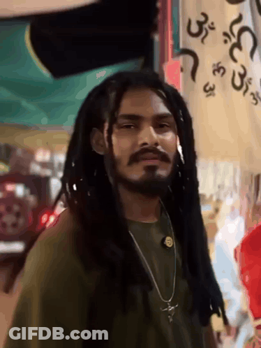 Dreadlocked Bearded Man Near Arabic Sign GIF