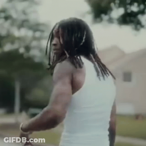Dreadlocked Man In White Tank Top By Building GIF