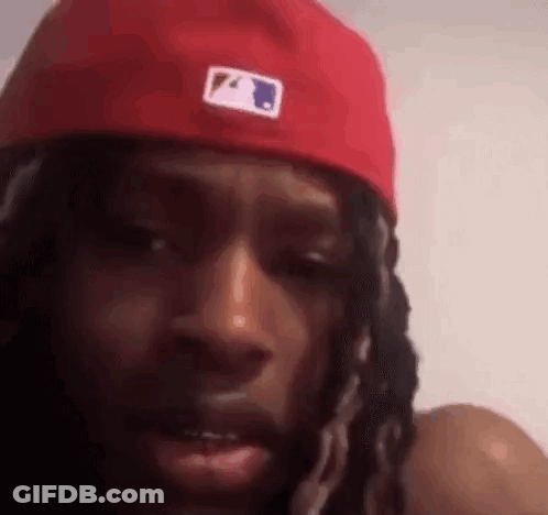 Dreadlocked Man With Red Hat Looking At Camera GIF