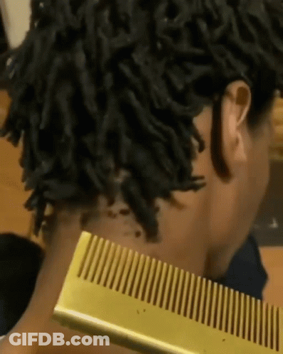 Dreadlocked Woman Holding Gold Comb To Neck GIF