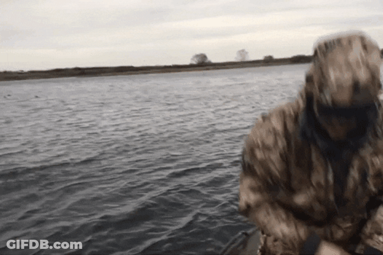 Duck Hunting Man In Decoy Throws Bait GIF