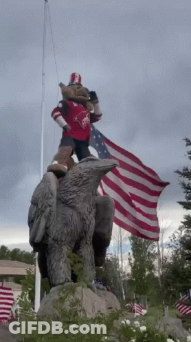 Eagle Statue With Mascot Holding American Flag GIF