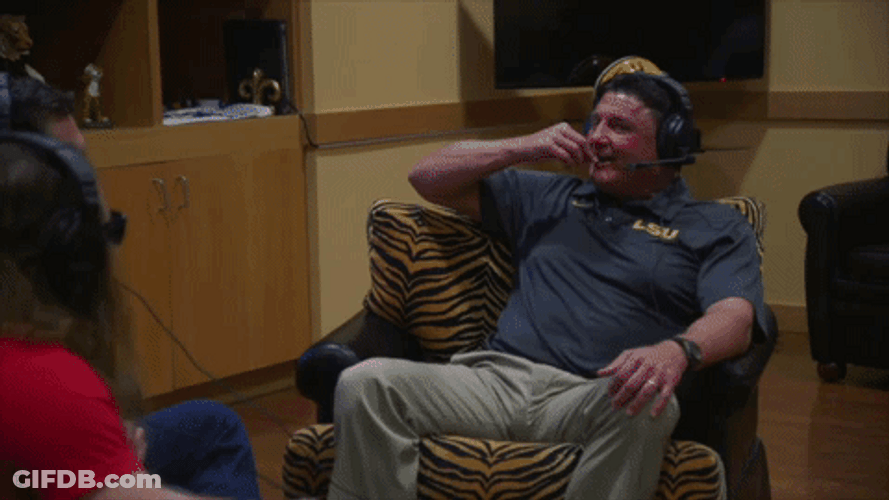 Ed Orgeron Holding Up His Fist While Laughing GIF