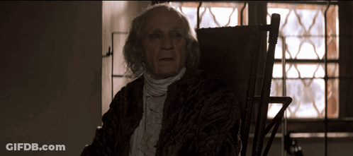 Elderly Man In Rocking Chair By Stained Glass Window GIF