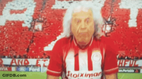 Elderly Man In Stoiximan Shirt In Front Of Crowd GIF