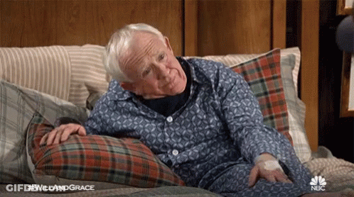 Elderly Man Laying On Bed With Plaid Pillow GIF