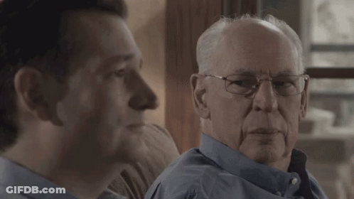 Elderly Man With Glasses Sitting On Couch With Another Man GIF