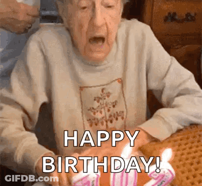 Elderly Woman Blowing Out Birthday Candles Saying Happy Birthday GIF