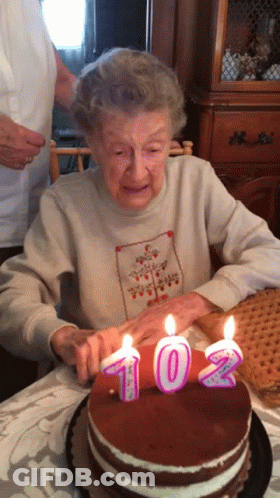 Elderly Woman Blowing Out Candles On 102 Cake GIF