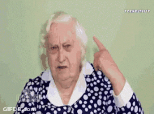Elderly Woman In Blue And White Polka Dot Dress Covering Ear GIF