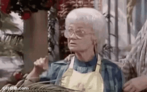 Elderly Woman In Glasses And Apron Sitting GIF