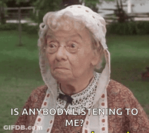 Elderly Woman In Glasses And White Hat Asking If Anyone Is Listening GIF