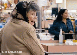 Elderly Woman In Head Scarf Standing In Store GIF