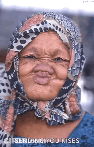 Elderly Woman In Scarf Making Funny Face Blowing Kisses GIF