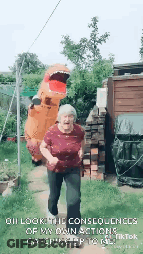 Elderly Woman In T-Rex Costume Dancing In Garden GIF