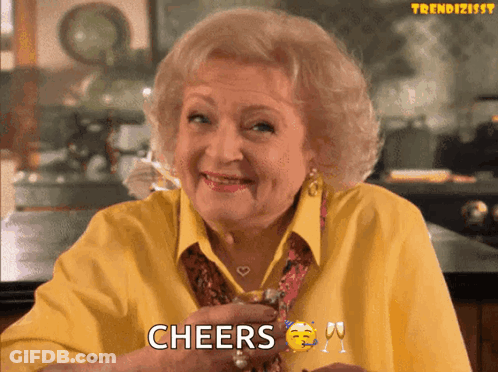 Elderly Woman In Yellow Shirt Cheers With Wine GIF