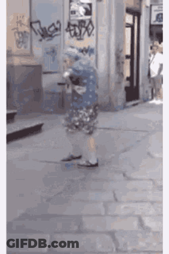 Elderly Woman Walking Down Sidewalk GIF