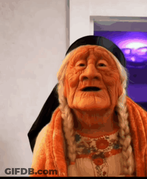 Elderly Woman With Braids In Orange Sweater And Black Scarf GIF