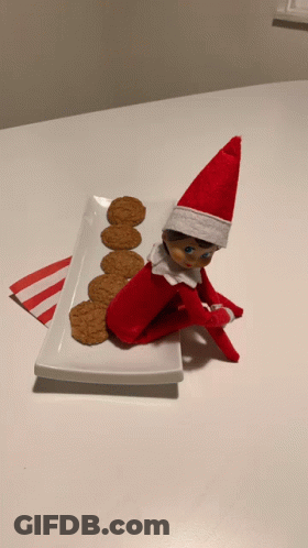 Elf On The Shelf Sits On Plate With Cookies GIF