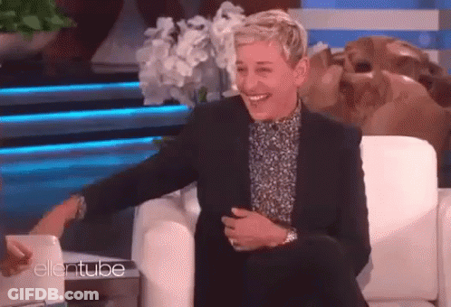 Ellen Degeneres Is Laughing While Sitting In A Chair On Ellentube GIF
