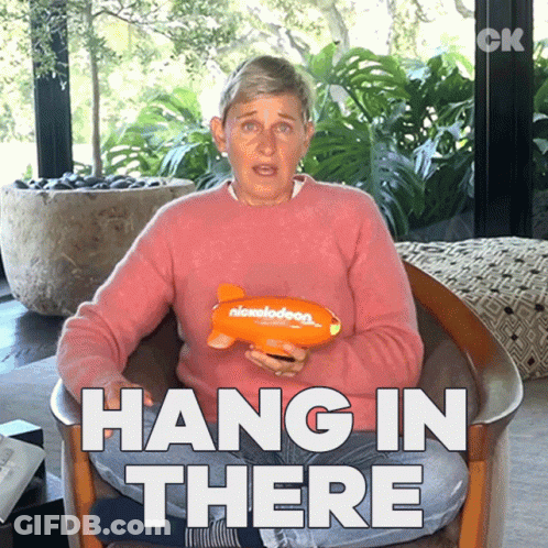 Ellen Degeneres Is Sitting In A Chair Holding A Nickelodeon Toy And Says Hang In There GIF