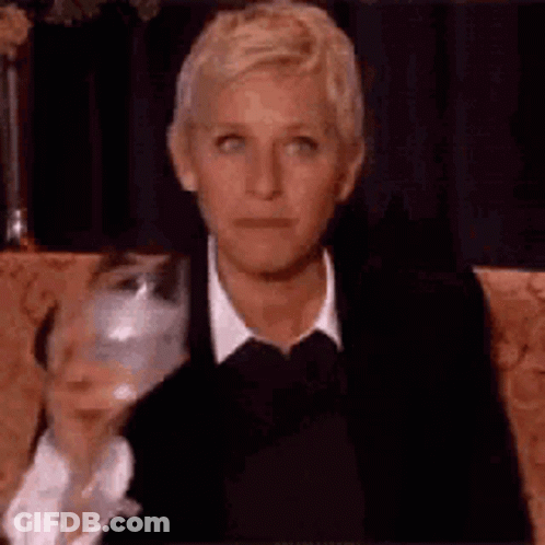 Ellen Degeneres Is Sitting On A Couch With A Glass Of Wine . GIF