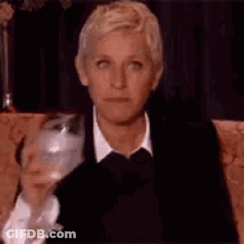 Ellen Degeneres Is Sitting On A Couch With A Glass Of Wine . GIF