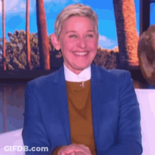 Ellen Degeneres Is Smiling While Sitting On A Couch In Front Of A Window . GIF