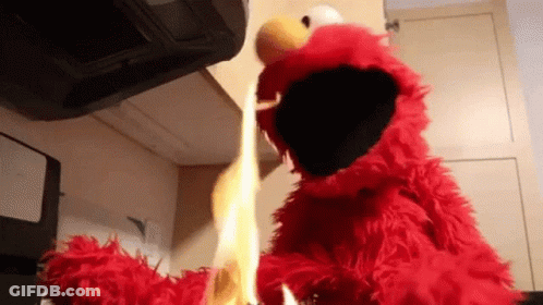 Elmo From Sesame Street Is Holding A Flame In His Hands GIF