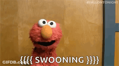 Elmo From Sesame Street Is Sitting In Front Of A Wooden Wall And Saying Swooning . GIF