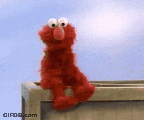 Elmo From Sesame Street Is Sitting On A Wooden Box GIF