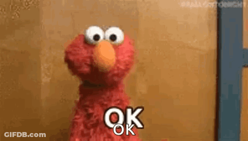 Elmo From Sesame Street Is Standing In Front Of A Door And Saying `` Ok '' . GIF
