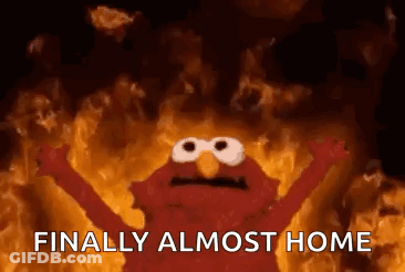 Elmo From Sesame Street Is Standing In Front Of A Fire . GIF
