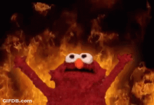 Elmo From Sesame Street Is Standing In Front Of A Fire With His Arms Outstretched . GIF