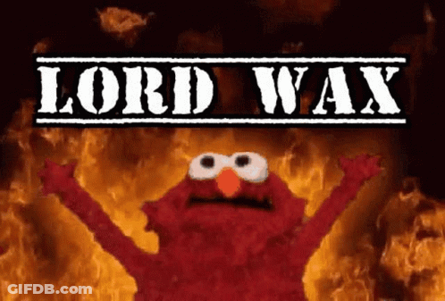 Elmo From Sesame Street Is Standing In Front Of A Fire With The Words Lord Wax Above Him . GIF