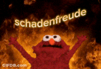 Elmo From Sesame Street Is Standing In Front Of A Fire With The Words Schadenfreude Above Him GIF