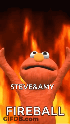 Elmo From Sesame Street Is Standing In Front Of A Fireball With His Arms Up . GIF