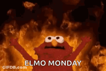 Elmo From Sesame Street Is Standing In Front Of A Wall Of Fire . GIF