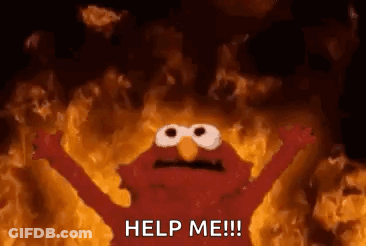Elmo From Sesame Street Is Standing In Front Of A Wall Of Fire . GIF