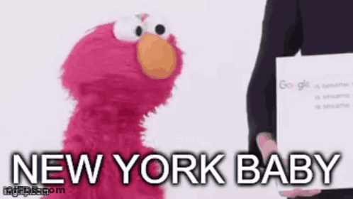Elmo From Sesame Street Is Standing Next To A Person Holding A Sign That Says New York Baby . GIF